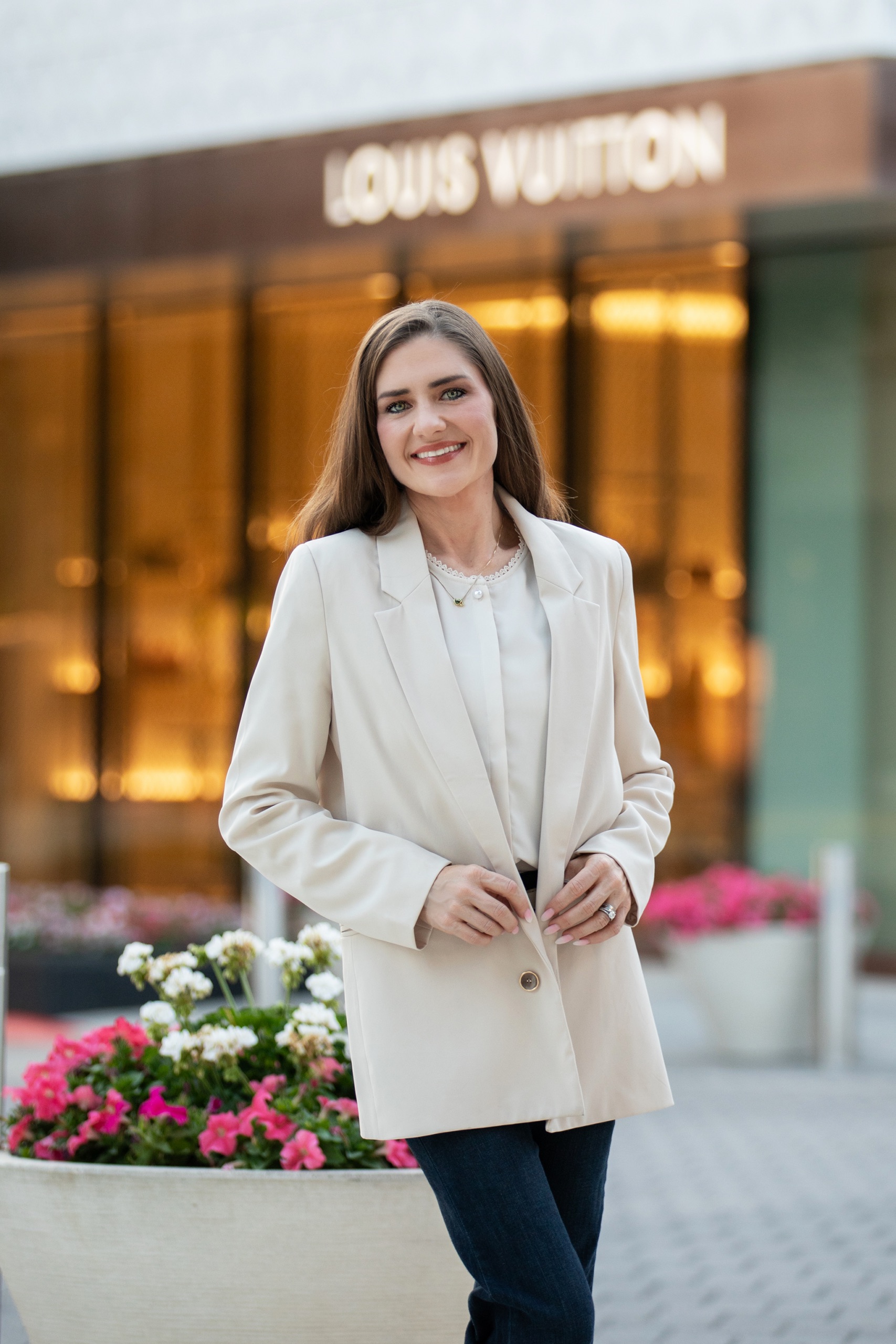 Jessica Cernat in a cream blazer in front of a Louis Vuitton storefront